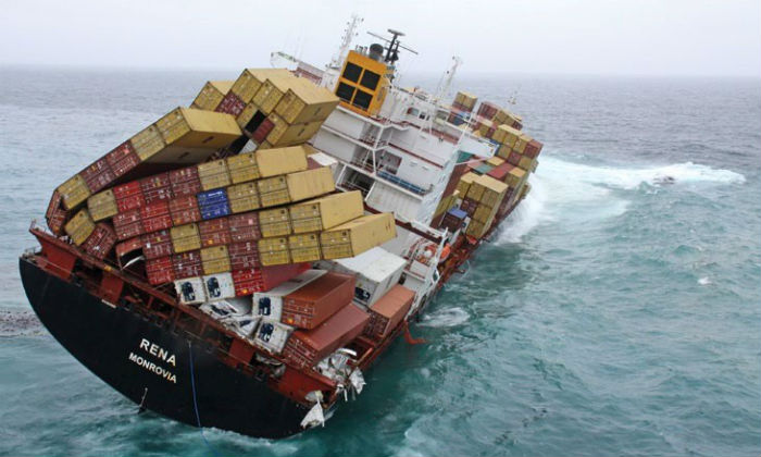 Cargo ship tipping over in ocean.