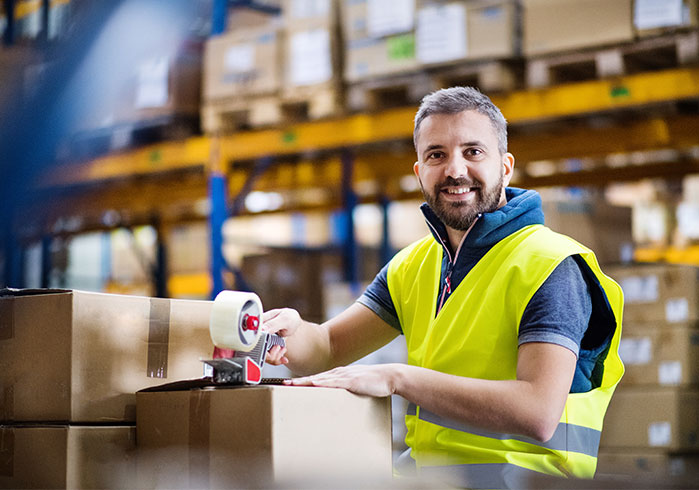 Warehouse employee wrapping boxes